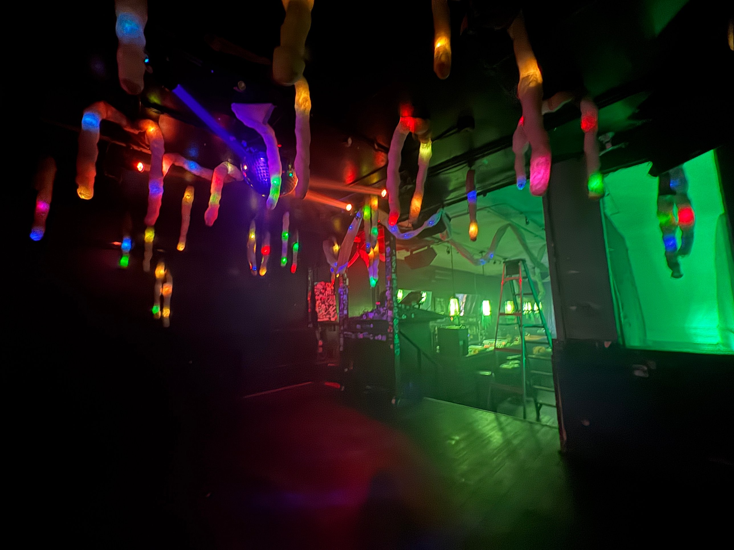 Glowing stalactites hanging over the dance floor, the bar lit green beyond