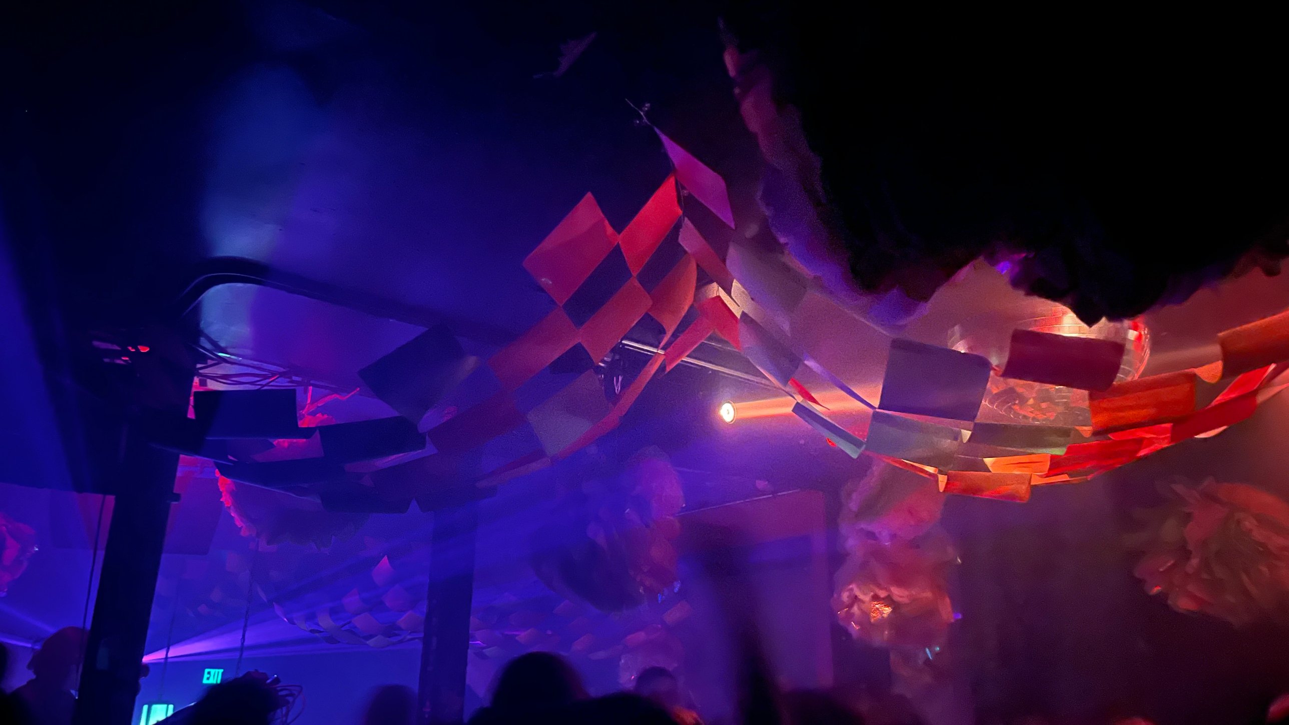 Checkered streamers sweeping across the ceiling in blue and red light over the crowd