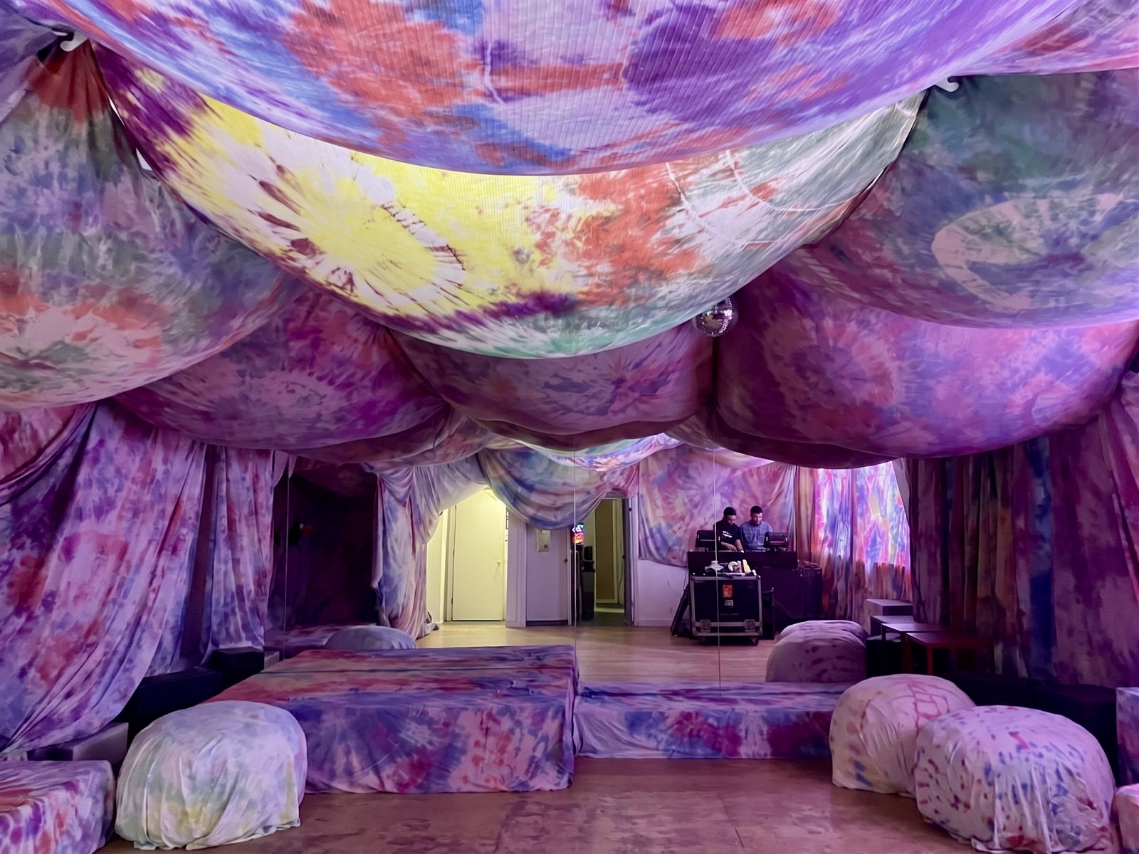 The tie-dye canopy fully draped before the crowd arrives