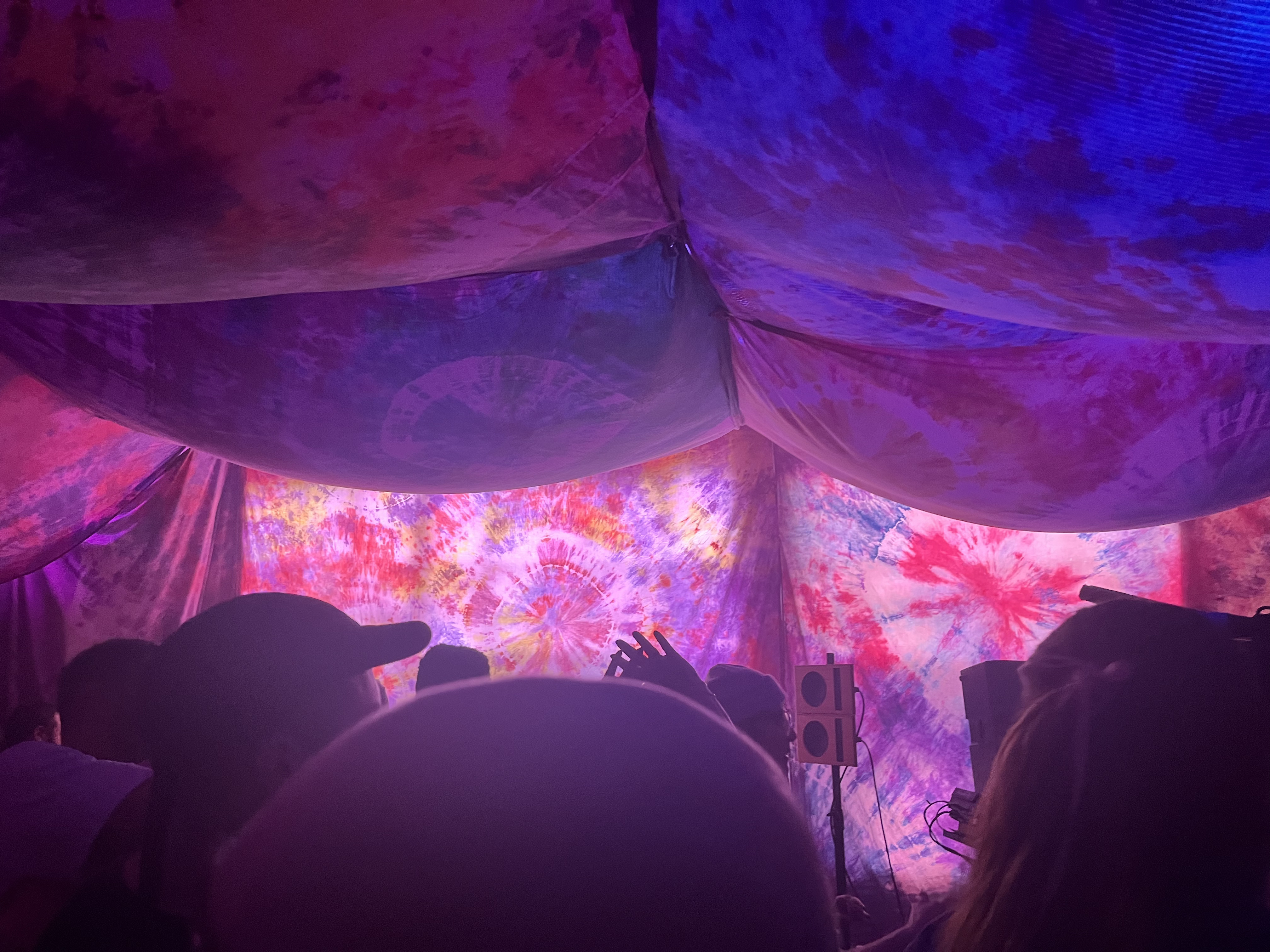 Crowd beneath the draped tie-dye canopy