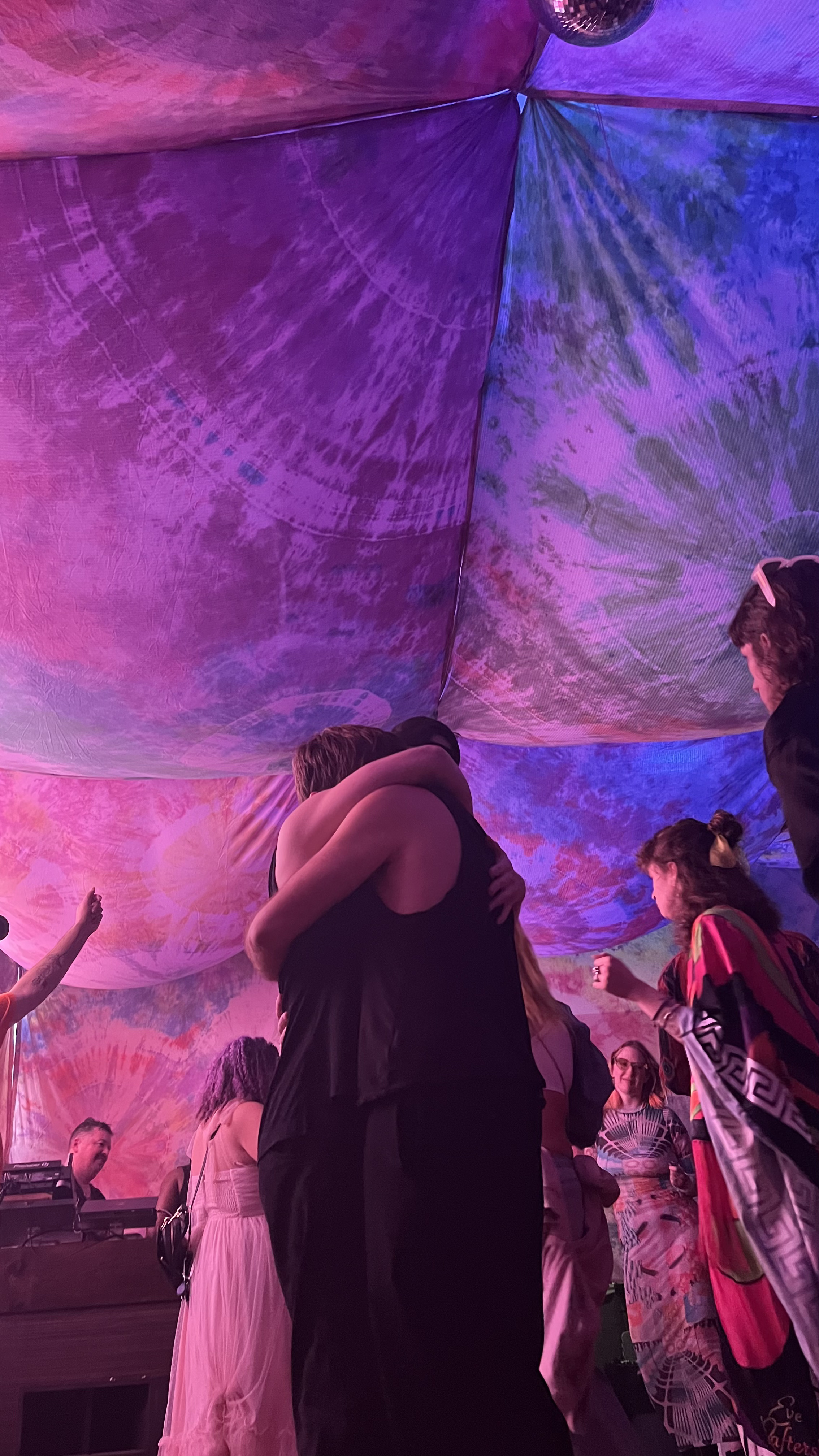 Two people embracing on the floor under the canopy