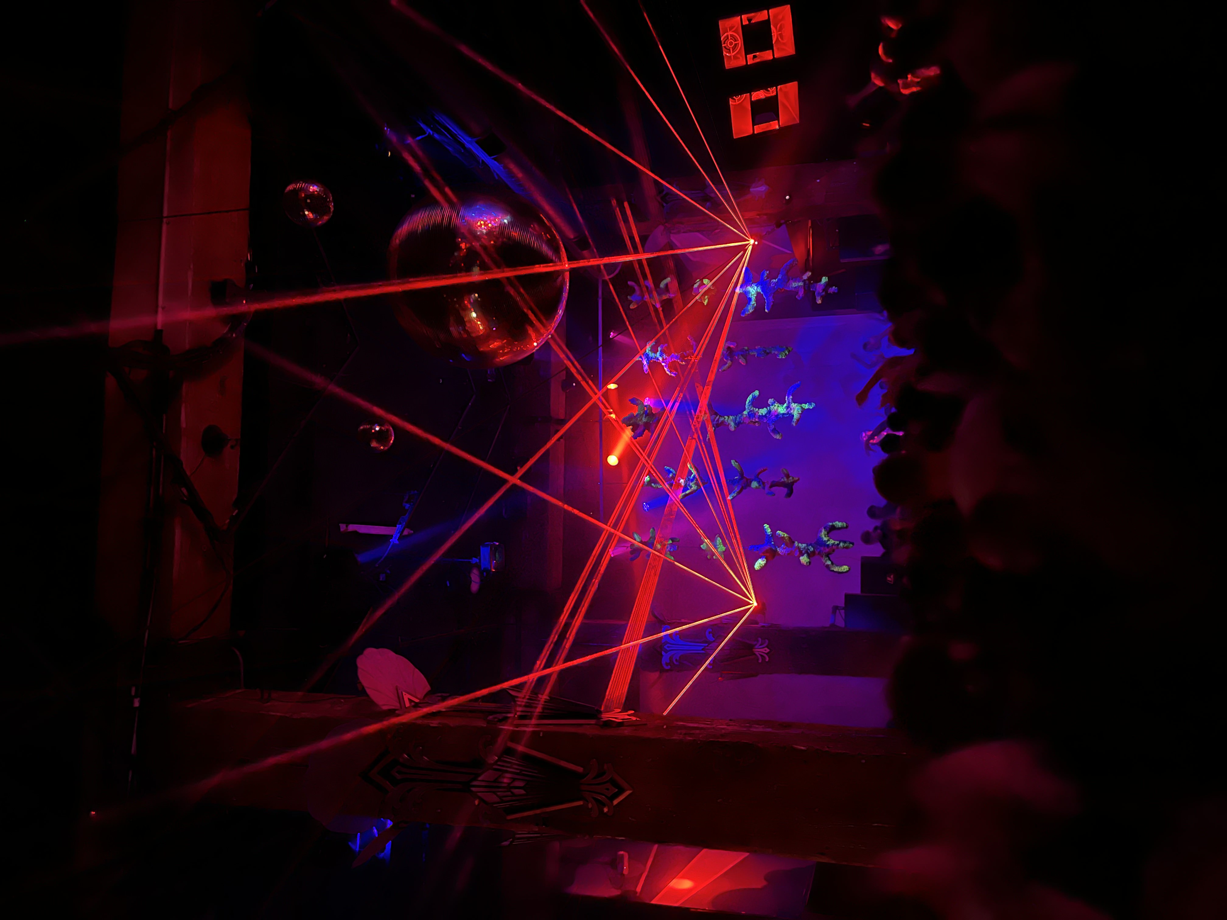 Red laser fans and a mirror ball over the sculptures